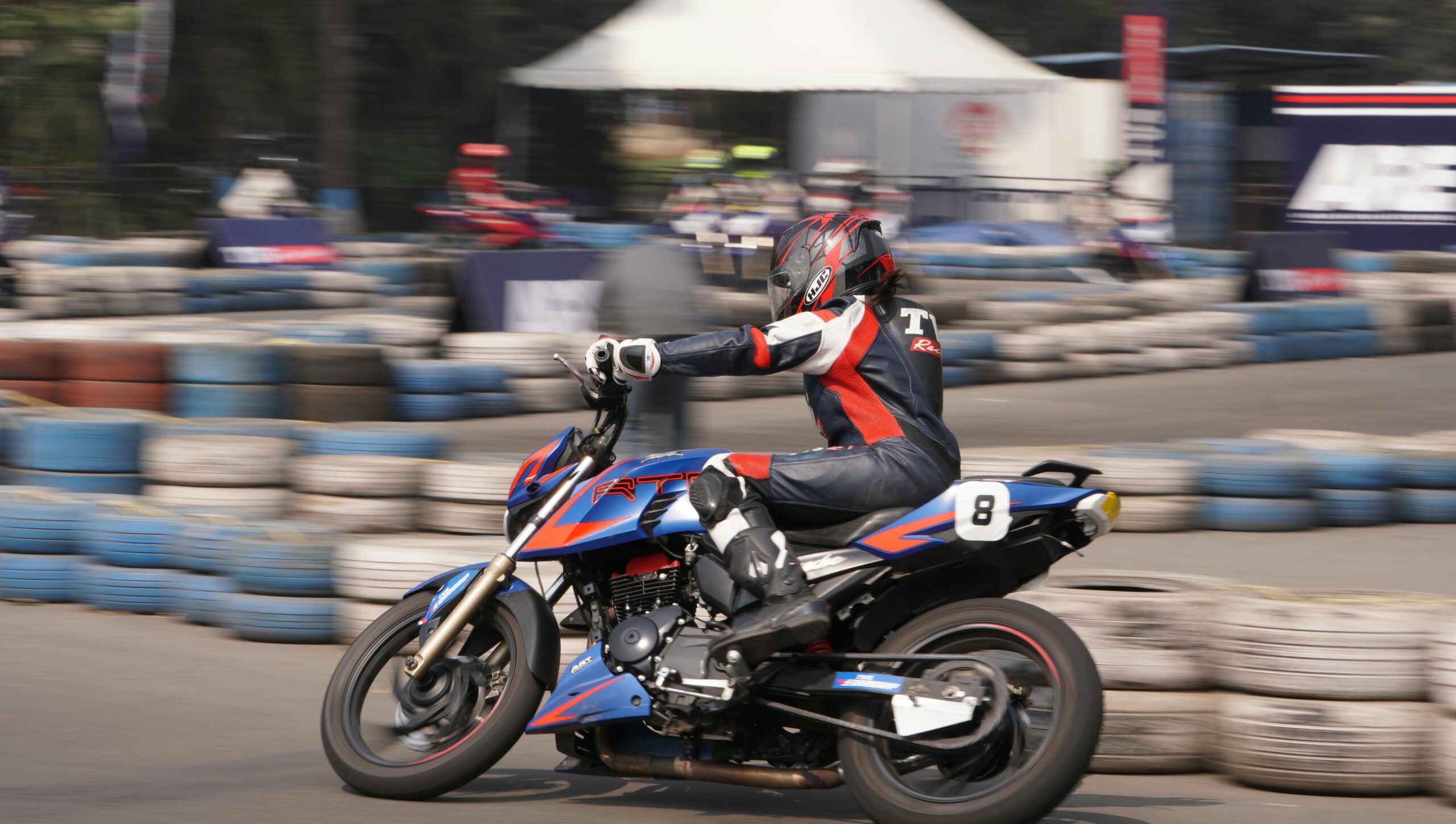 A seasoned MotoGP rider navigating sharp turns on a wet track