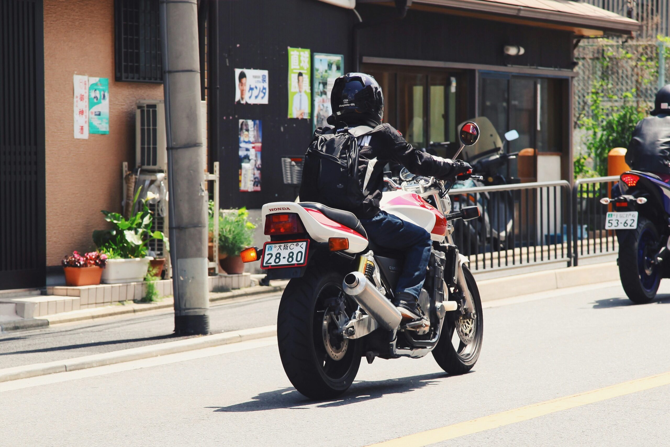 MotoGP rider wearing full protective gear including helmet, suit, gloves, and boots