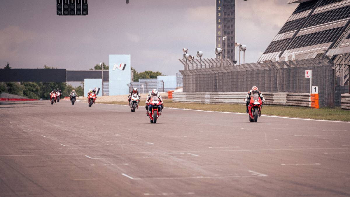 Close-up action shot of a MotoGP rider leaning into a high-speed corner