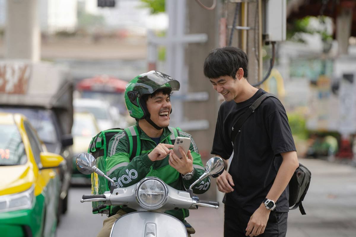 A MotoGP rider holding a phone at a pit stop