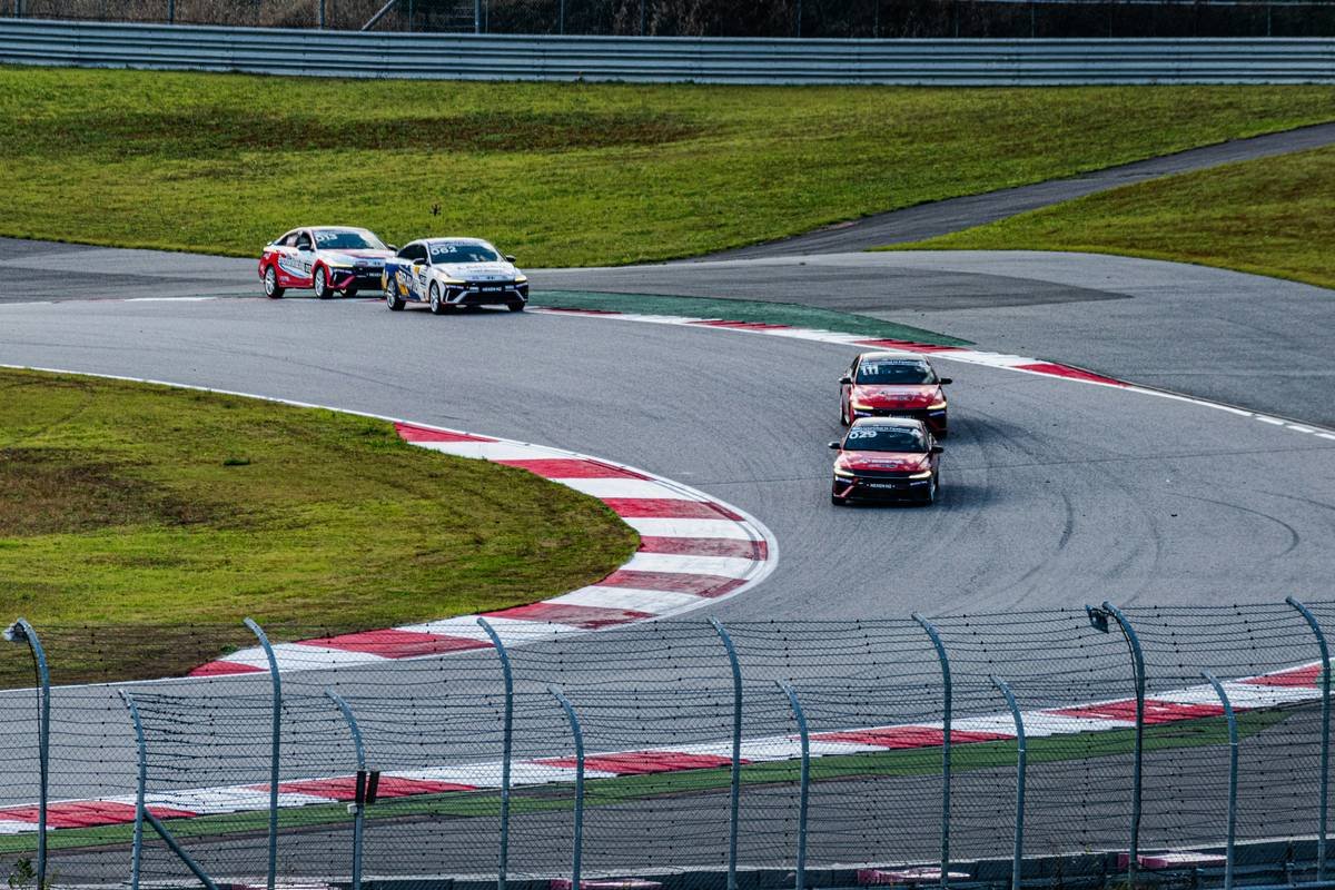 A photo showing a bustling circuit media center with monitors displaying live feeds of MotoGP races.